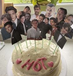 a birthday cake with pictures of people on it and candles in the shape of hearts