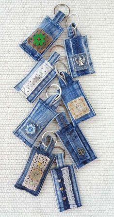 several pieces of blue jean fabric with buttons and lace hanging from the bottom, on a white background