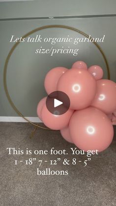 a bunch of pink balloons sitting on top of a floor next to a round frame