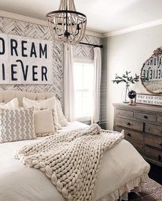 a bedroom with a bed, dressers and a chandelier hanging from the ceiling