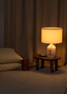 a table with a lamp on it next to pillows