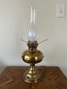 an antique brass oil lamp on a wooden table