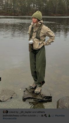 a man standing in the water with his hands on his hips and holding a cup