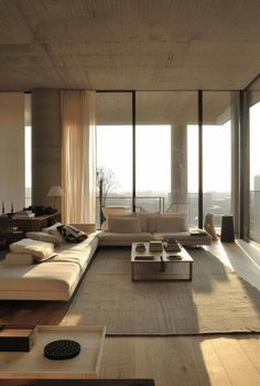 a living room filled with furniture and large windows