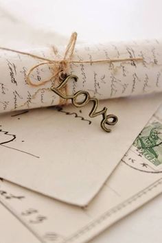 two envelopes tied with twine and some type of love on top of each other