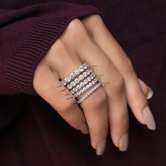 a woman's hand with three rings on her fingers and one ring in the middle