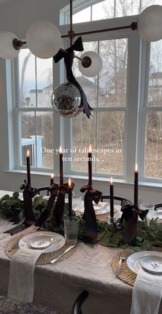 a dining room table with candles and plates on it