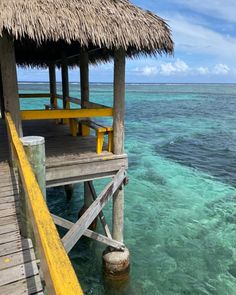 the water is crystal blue and clear with yellow steps leading to an overhanged hut