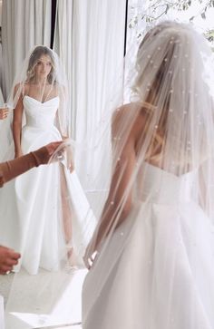 the bride is getting ready to walk down the aisle in her wedding dress and veil