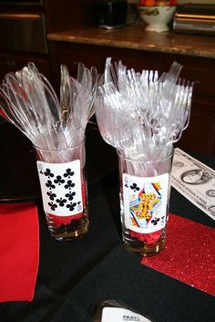 two clear vases sitting on top of a table covered in plastic wrappers and paper