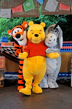 winnie the pooh and tigger standing next to each other