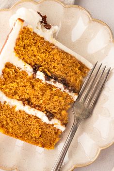 a piece of carrot cake on a plate with a fork