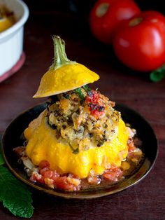 a plate with some food on top of it and tomatoes in the backround