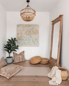 a large mirror sitting on top of a wooden floor next to a potted plant