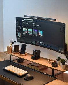 a flat screen tv sitting on top of a wooden desk next to a keyboard and mouse