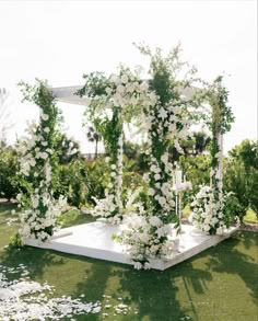 an outdoor wedding setup with white flowers and greenery