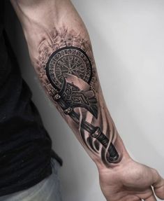 a man with a tattoo on his arm holding a clock and wrench in one hand