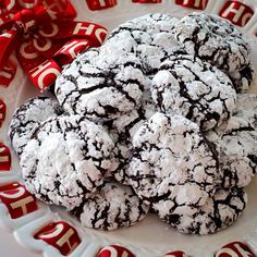 chocolate crinkle cookies on a white plate with red ribbon around the edges and letters