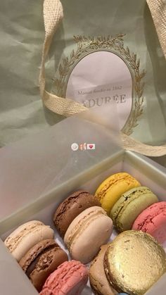 a box filled with assorted macaroons sitting on top of a table