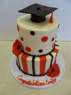 a graduation cake with an orange and white striped design on top, decorated with poppies