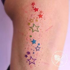 a woman's thigh with colorful stars on it and the word, star tattoos