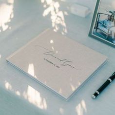 a notepad and pen sitting on top of a table next to a framed photo