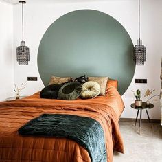 a bed with an orange bedspread and green pillows