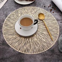 a cup of coffee sitting on top of a table next to a plate with donuts