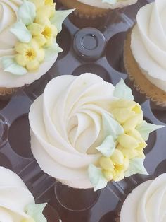 several cupcakes with white frosting and yellow flowers