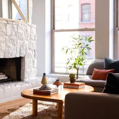 a living room filled with furniture and a fire place in front of a large window