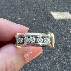 a person holding a ring with diamonds in it's middle finger on the street