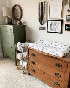 a baby's crib and dresser in a room with pictures on the wall