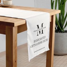 a table with a white cloth on it and a potted plant in the background