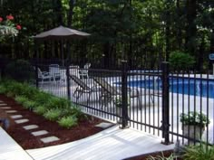 an outdoor pool and patio area next to a fence