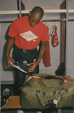 a man standing next to a luggage bag in a room with other items on the floor