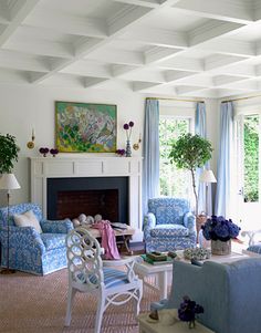 a living room filled with furniture and a fire place in front of a painting on the wall