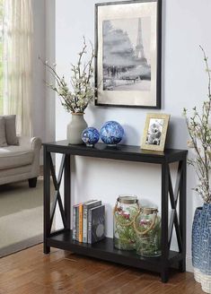 a black shelf with vases and pictures on it