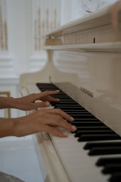 two hands are playing the piano together