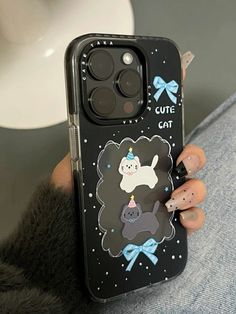 a woman holding up her phone case with an animal sticker on it