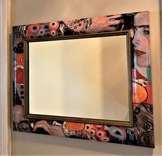 a mirror that is on the wall with some pictures around it and an image of a woman's face