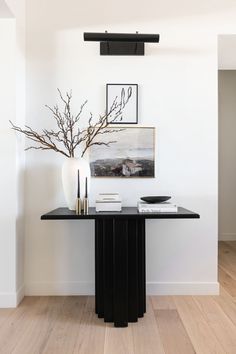 a black and white table in a room with pictures on the wall