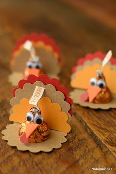 three little turkeys with candy on them sitting on a wooden table next to each other