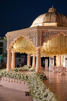 an elaborately decorated gazebo sits in the middle of a courtyard at night time