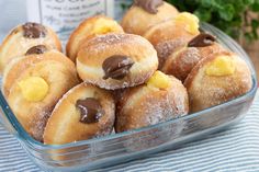 a glass bowl filled with chocolate covered donuts