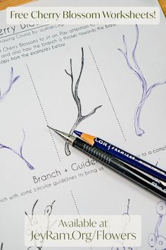 a close up of a pen on top of a sheet of paper with trees and branches