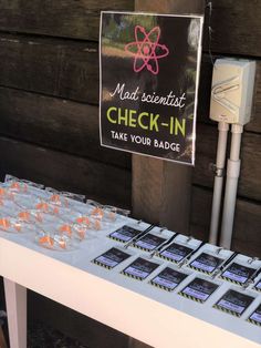 a sign that says mad scientist check - in next to some candies on a table