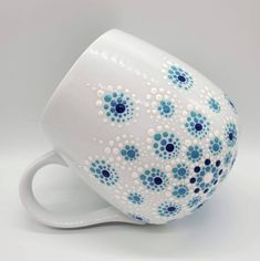 a blue and white coffee cup sitting on top of a table