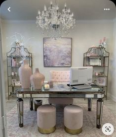 a desk with two stools in front of it and a chandelier hanging from the ceiling