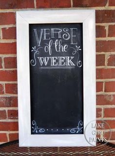 a chalkboard with the words verse of the week written on it in front of a brick wall