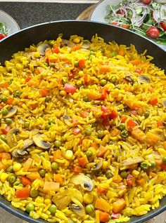 a pan filled with rice and vegetables on top of a table